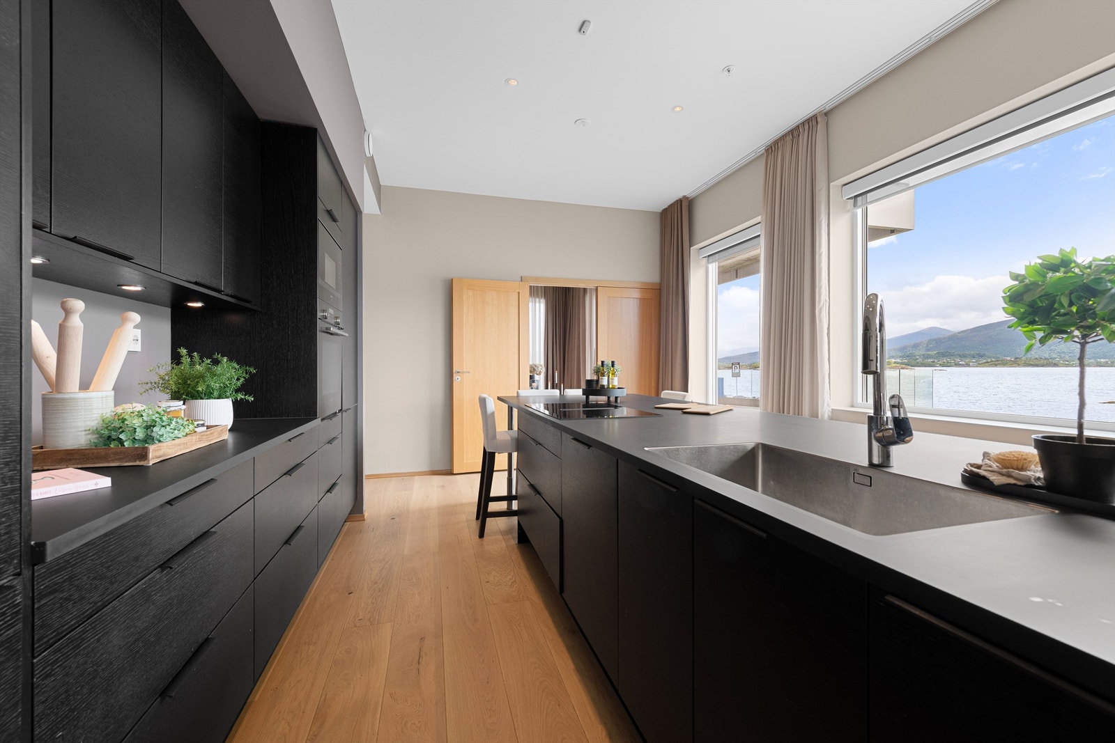 Kjøkkenet har innredning fra NOREMA med mørke fronter og benkeplate er av laminat Galleribilde