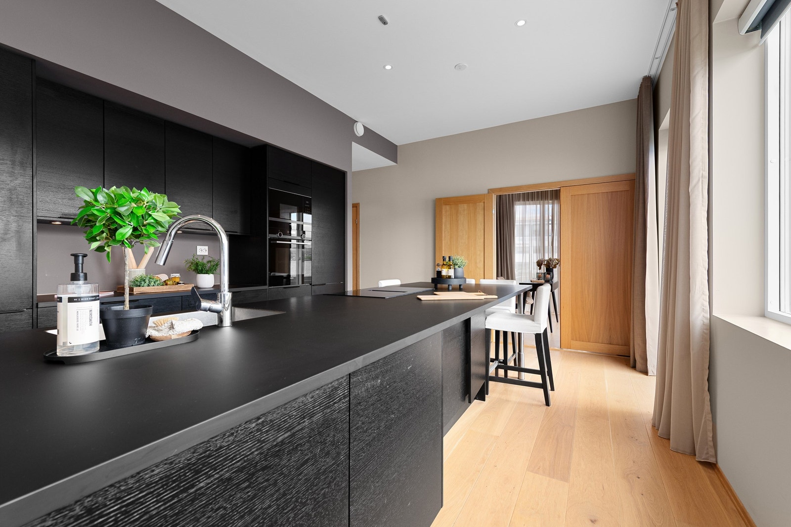 Stor og praktisk kjøkkenøy med nedfelt platetopp og nedfelt oppvaskkum med ett-greps kjøkkenarmatur.
Det er tilrettelagt for spiseplasser på kjøkkenøyen Galleribilde