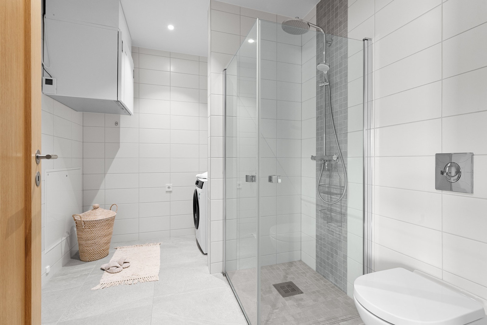 Bad nr. 2 /vaskerom med adkomst fra entre/hall. Dushjørne med glassvegger og vegghengt armatur med hånddusj og regndusj. Vegghengt toalett. Opplegg for vaskemaskin og tørketrommel Galleribilde