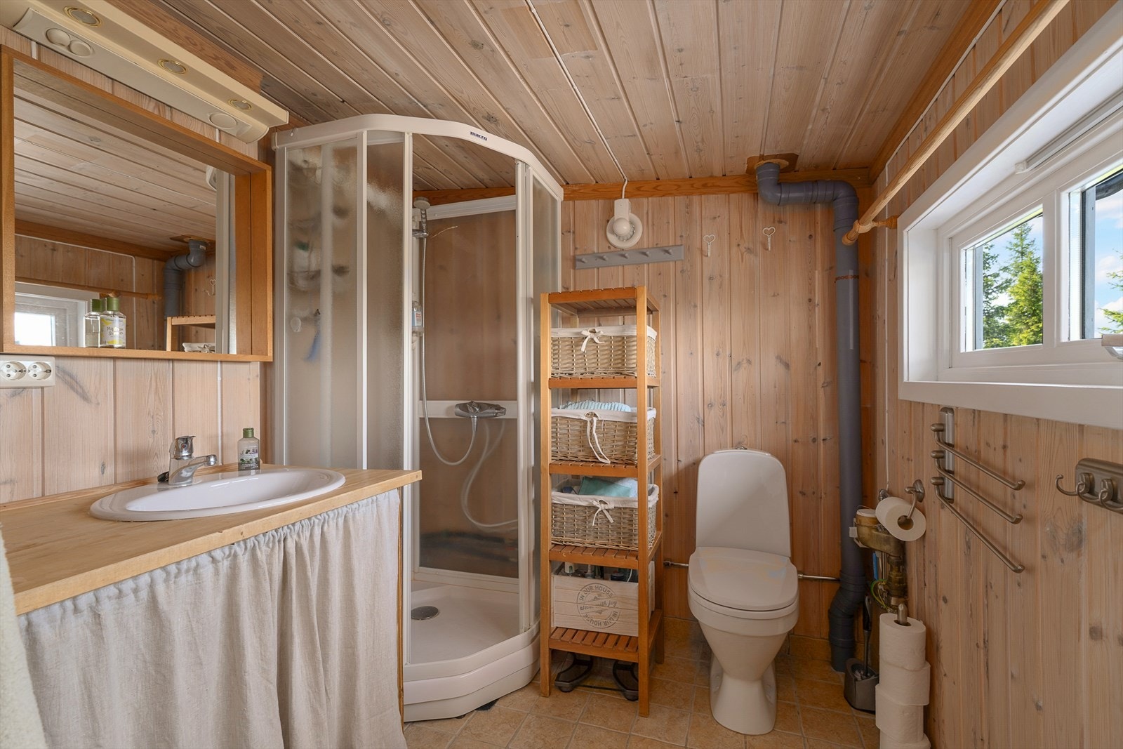 Praktisk baderom med toalett, dusj og servant. Det er varmekabler i gulvet på badet. Galleribilde