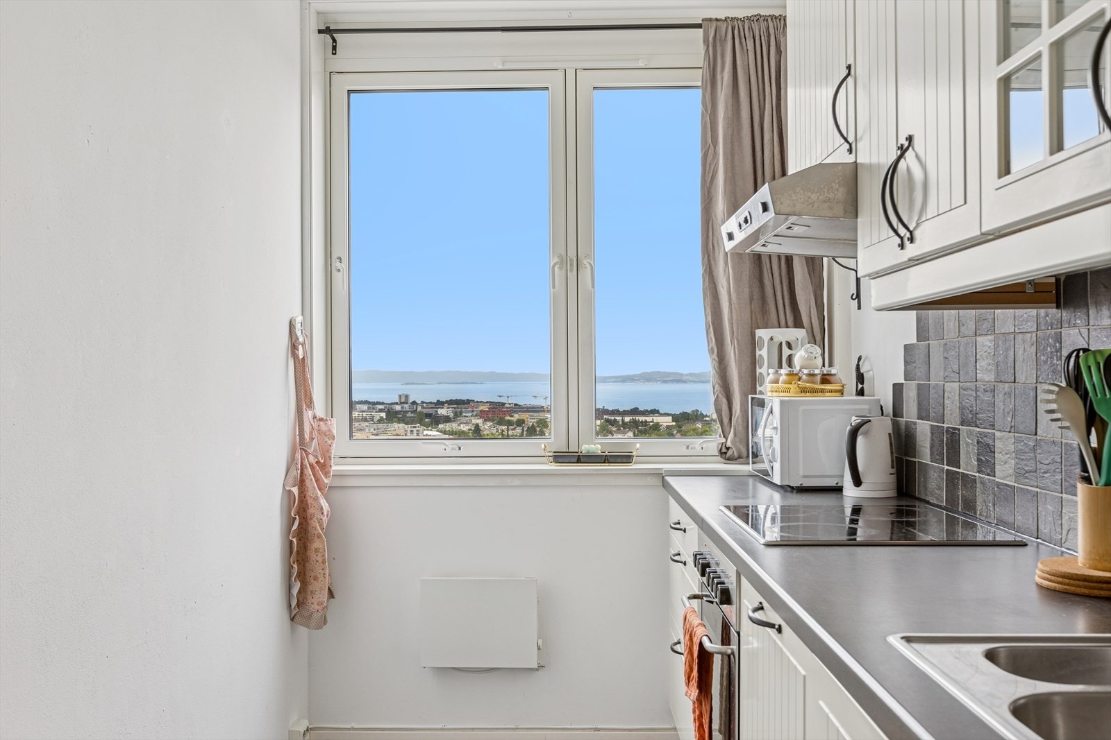 Kjøkkenet har rikelig med skap- og benkeplass, samt en fantastisk utsikt du kan nyte under matlagingen. Galleribilde