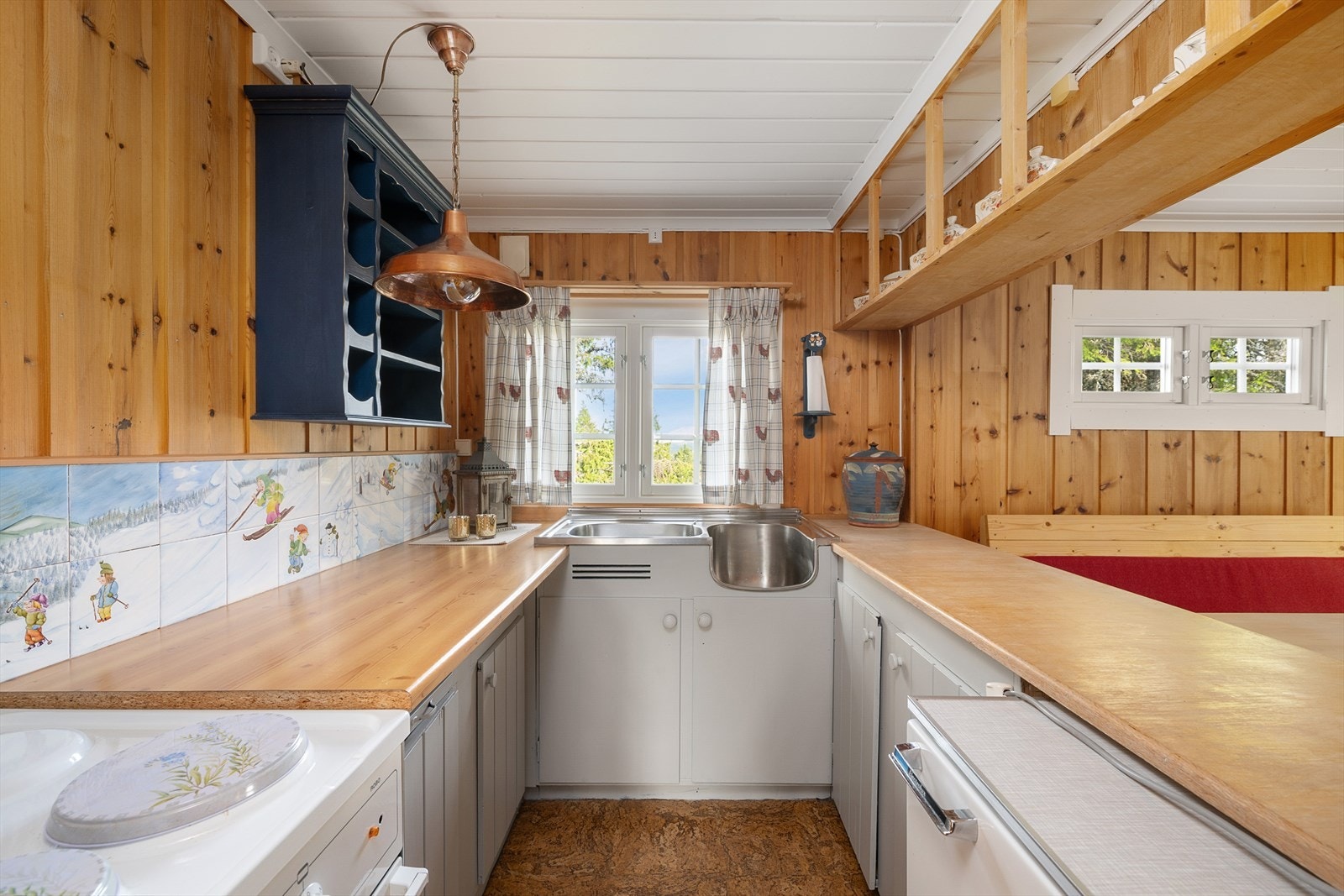 Kjøkken i U-form, forholdvis åpent mot spiseplassen. Godt med benkeplass. Vindu over kjøkkenbenken slipper inn fint lys. Galleribilde