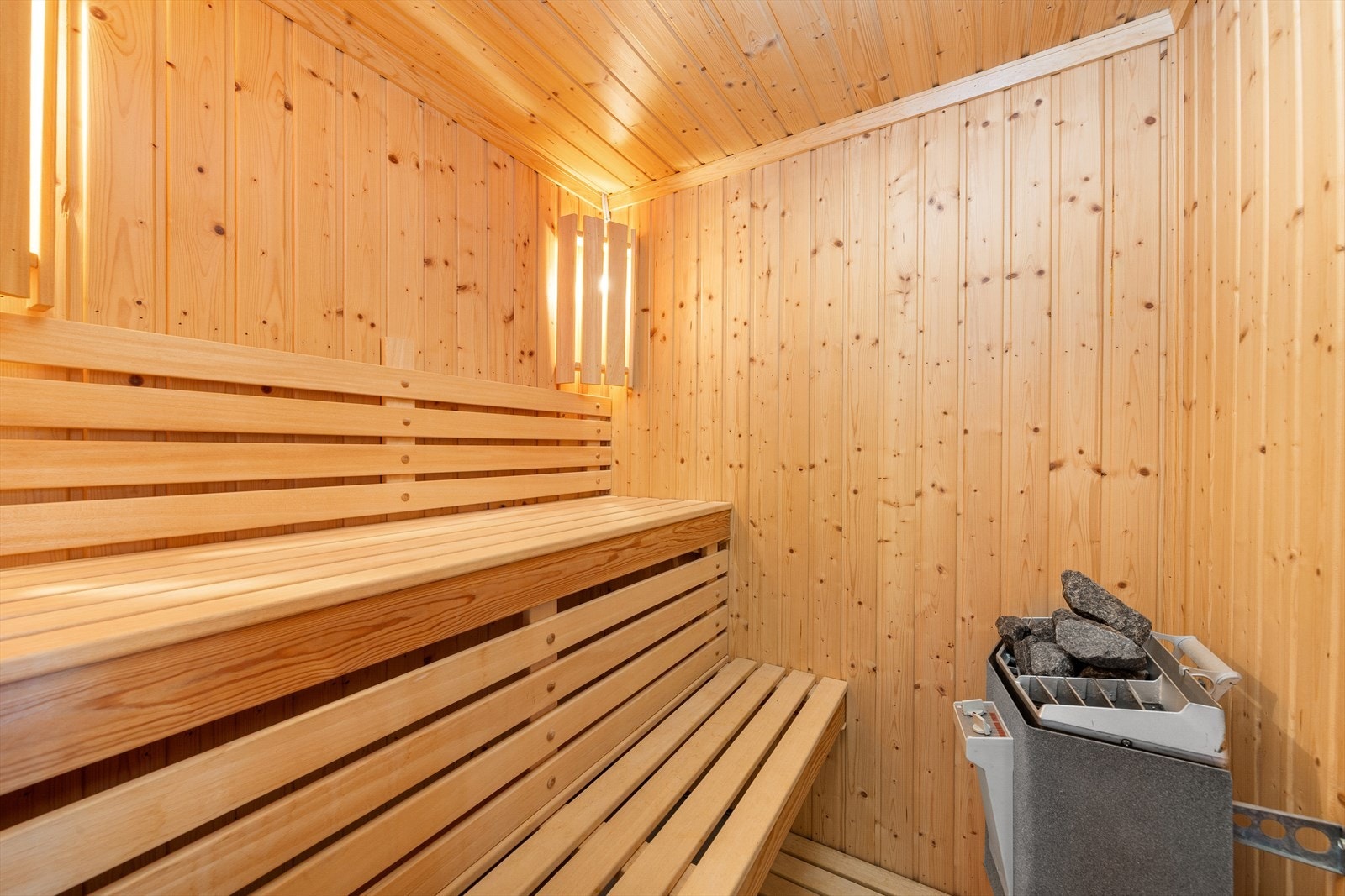 Badstuen har plassbygde sittebenker og en badstuovn. Galleribilde