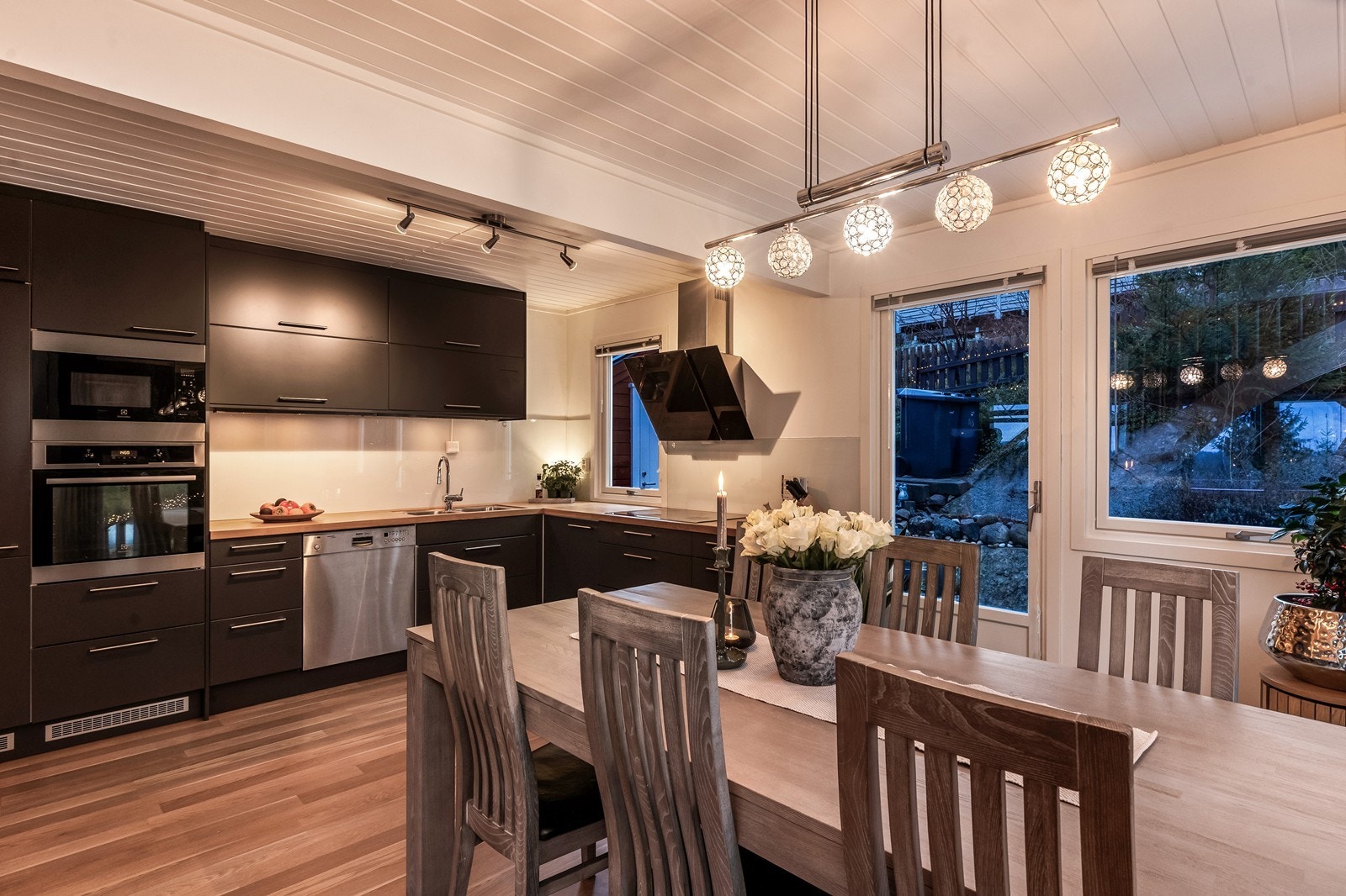 Kjøkkeninnredningen har en moderne utførelse med grå, slette fronter, heltre benkeplate og belysning under overskap. Galleribilde