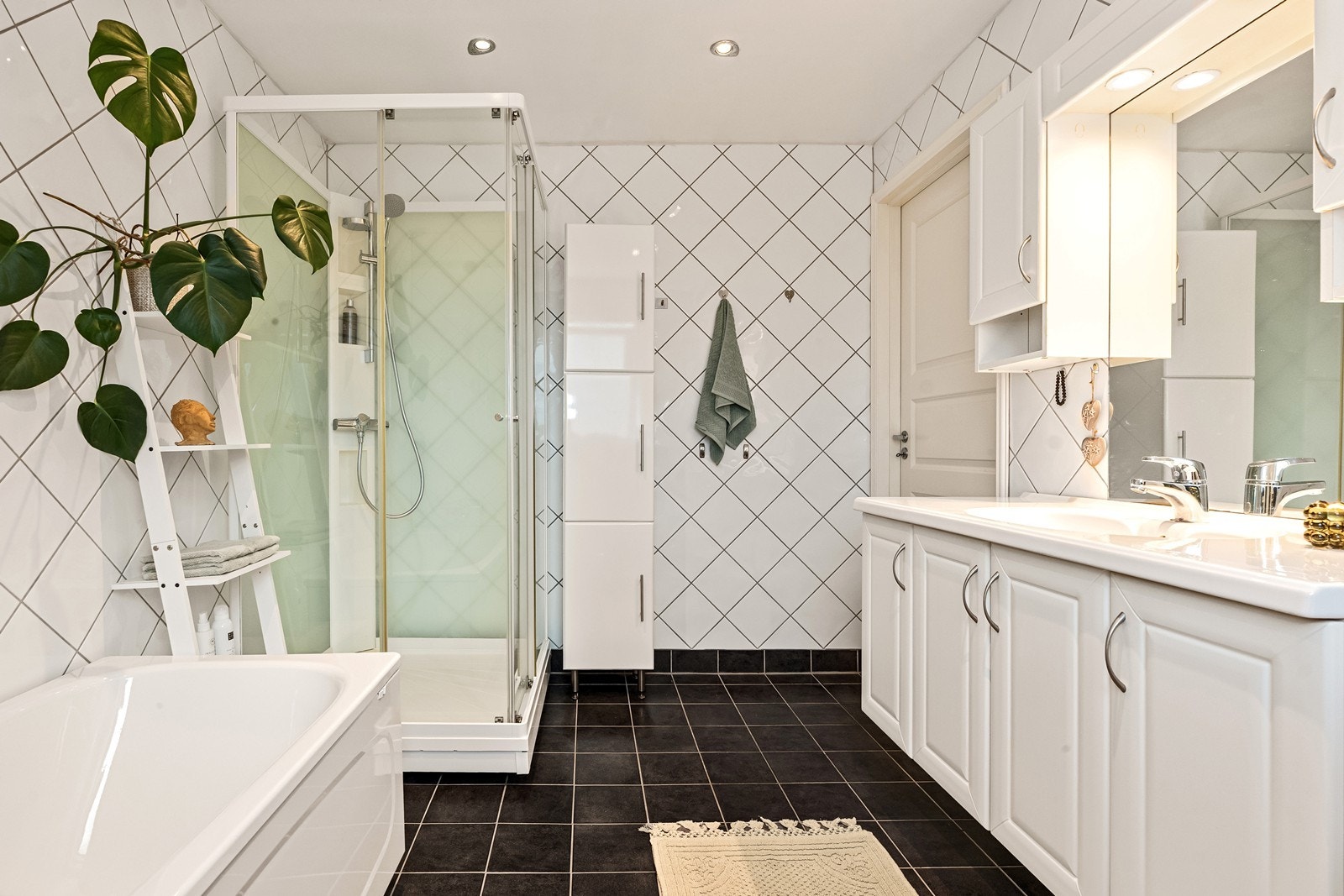 Badet er utstyrt med toalett, servant med skap, dusjakabinett og badekar. Galleribilde