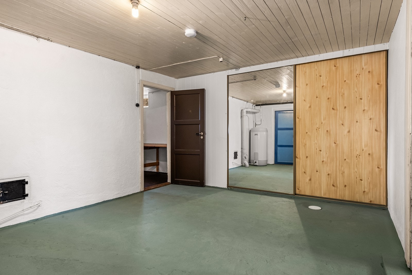 Innredet rom i kjeller med oppbevaringsplass i skyvedørsgarderobe. Galleribilde