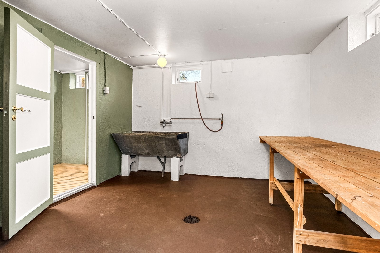 Vaskerom med malte betongoverflater, utslagsvask og mulighet for oppbevaring. Galleribilde