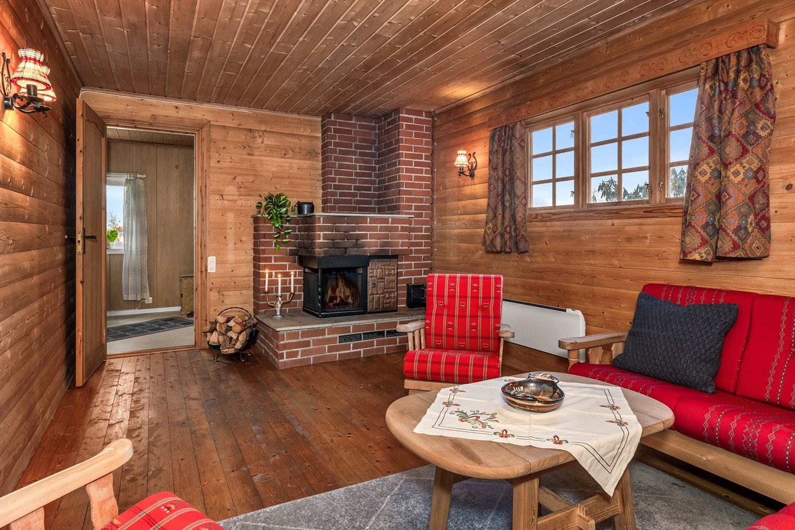 Koselig peisestue med panelte overflater og tregulv. Galleribilde