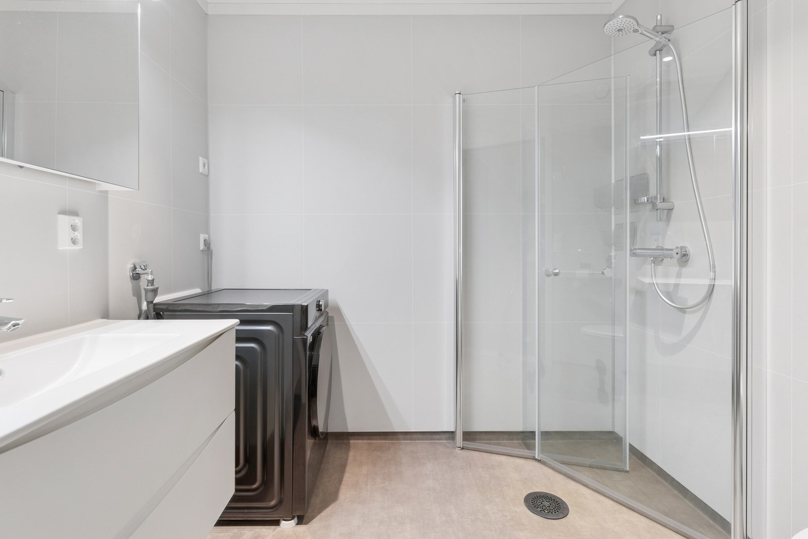 Badet har baderomsplater på veggene, dusjhjørne og opplegg for vaskemaskin. Galleribilde