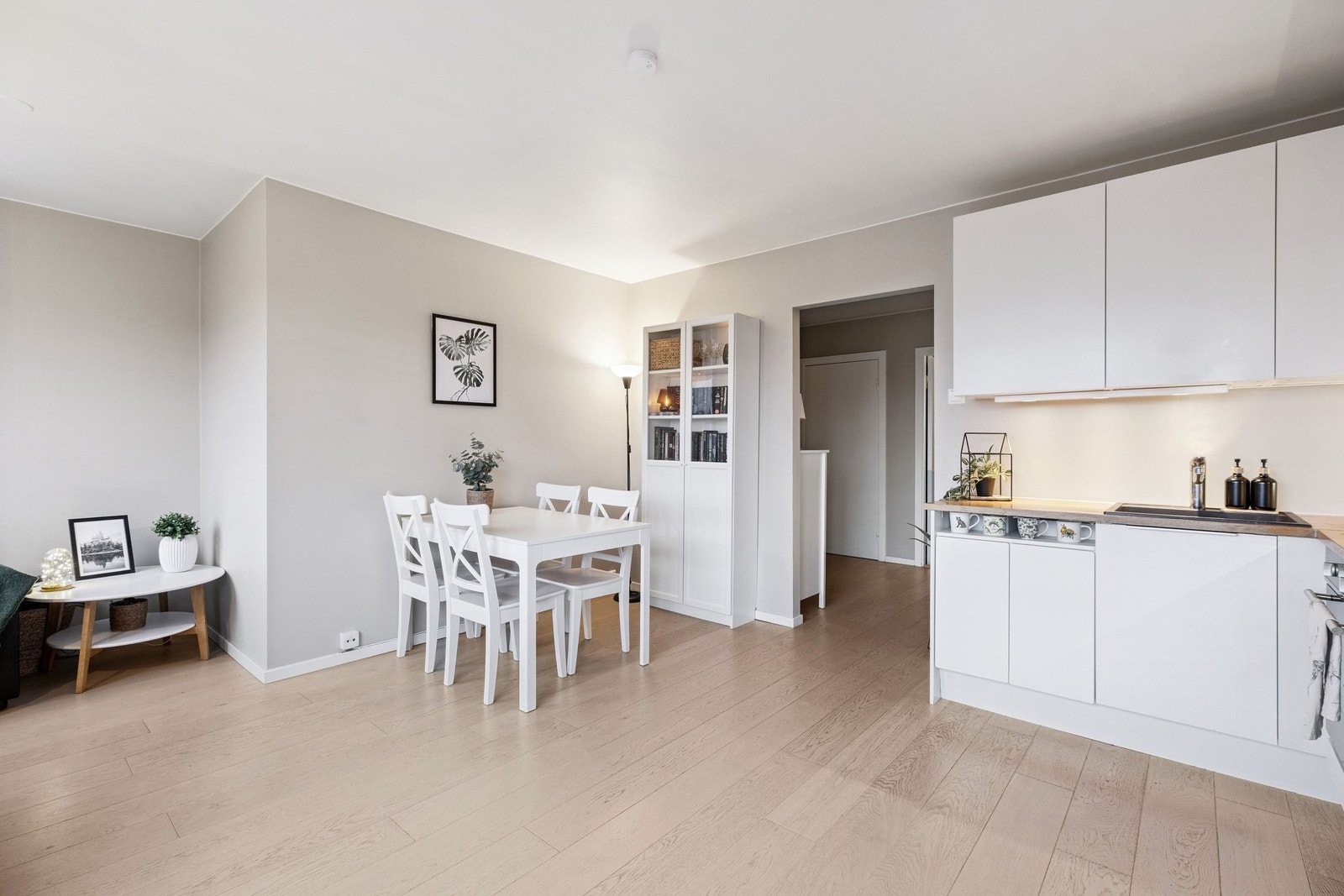 Hvit, stilren kjøkkeninnredning med benkeplate i heltre og ettgreps blandebatteri. Galleribilde