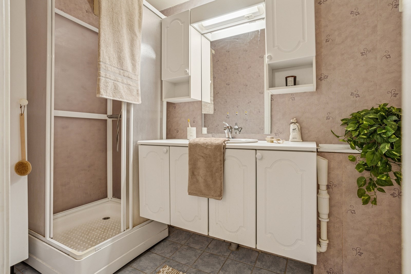 Eldre baderom med fliser på gulv og våtromstapet på vegger. Galleribilde