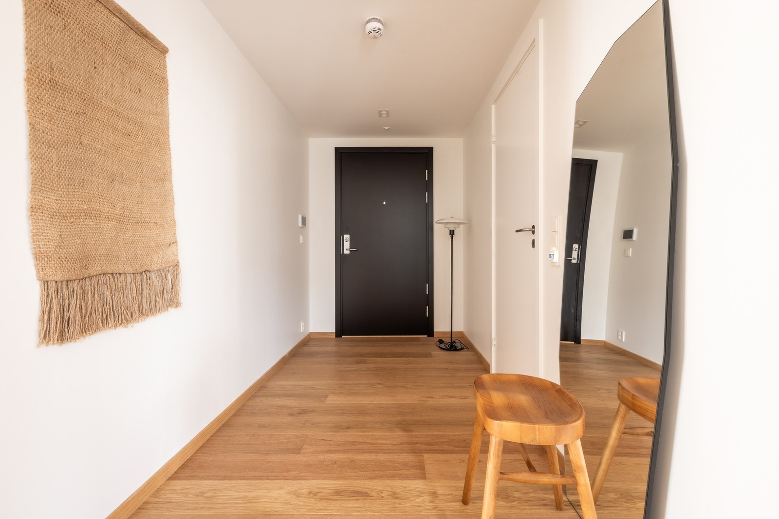 Innbydende entré med parkett på gulv, malte veggflater og glatt himling. Området gir en ryddig og moderne førsteopplevelse av leiligheten. Galleribilde