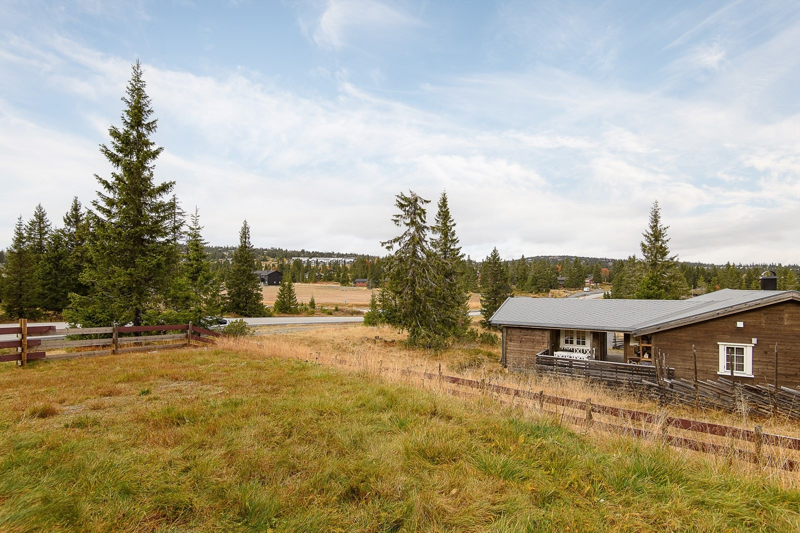 Delvis inngjerdet tomt gir et hyggelig tun utenfor hytta. Galleribilde