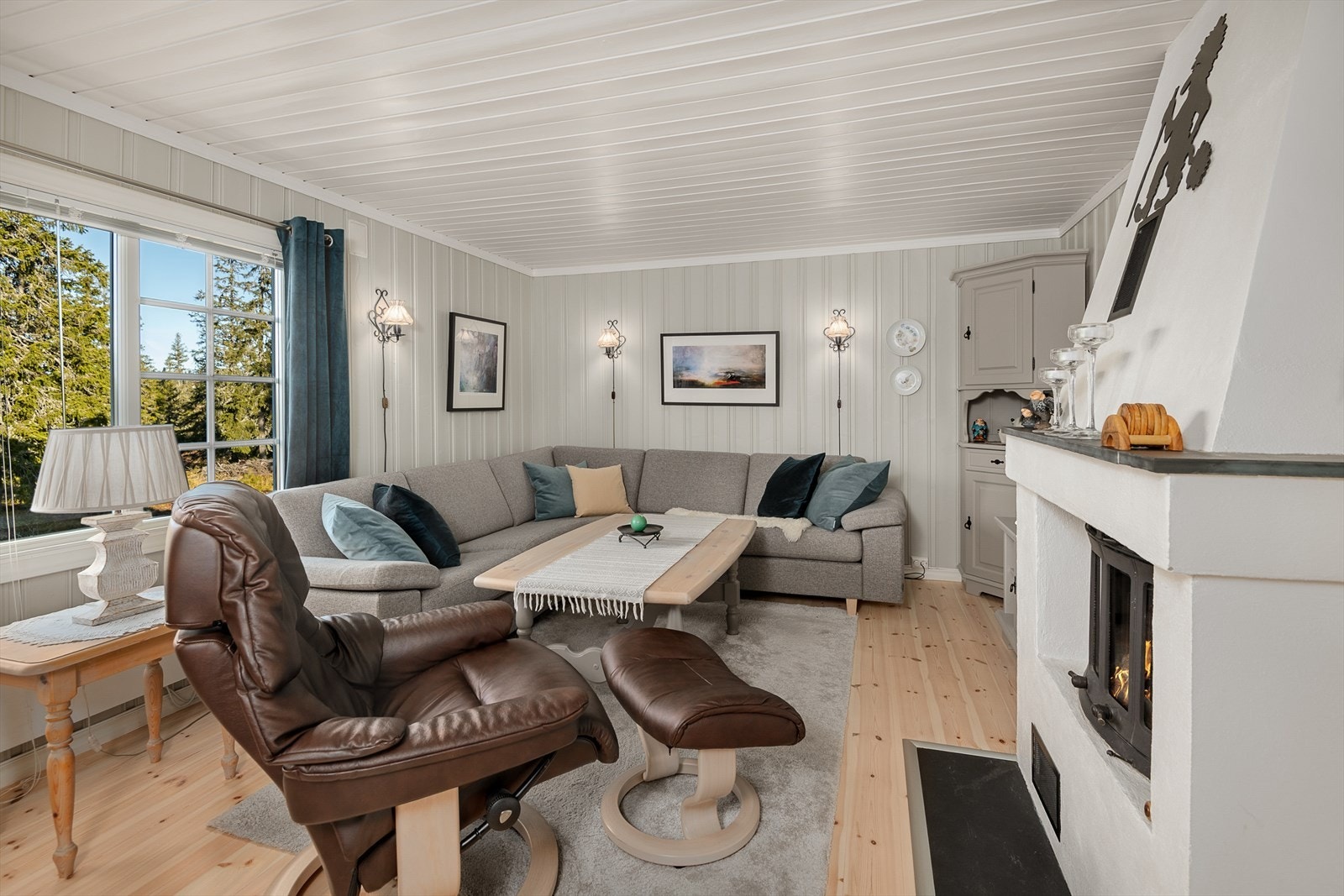 Stua er malt i lyse men lune fargetoner. God plass til en koselig sofakrok foran peisen. Galleribilde