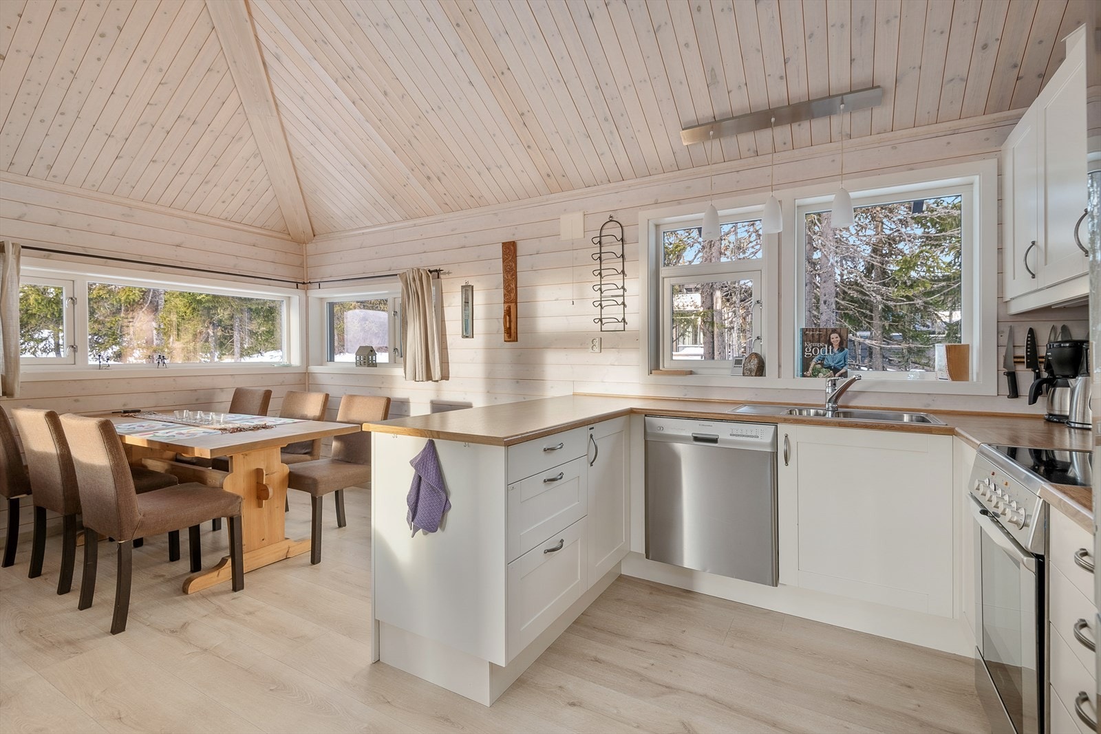 Innredningen på kjøkkenet er i en U-form og har fronter med lett profilering i en lys og tidløs fargetone. Galleribilde