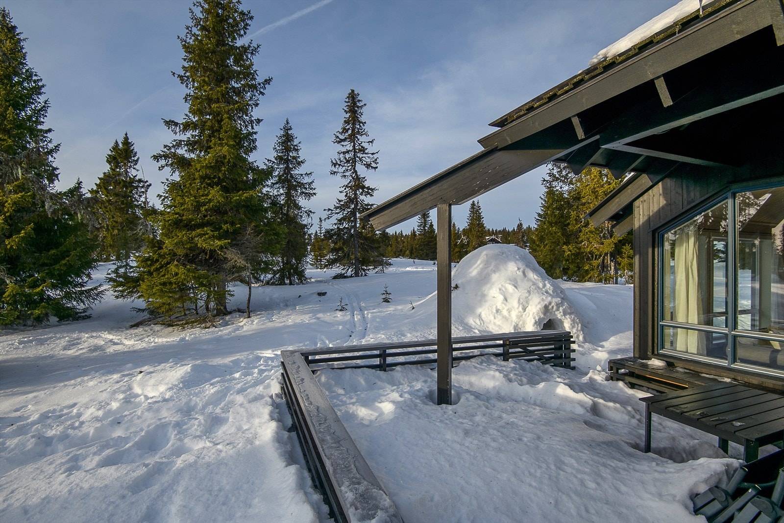 Romslig terrasse, som delvis er overbygget ved hytta. Her kan en slappe av i solveggen etter en dag ute på tur. Galleribilde