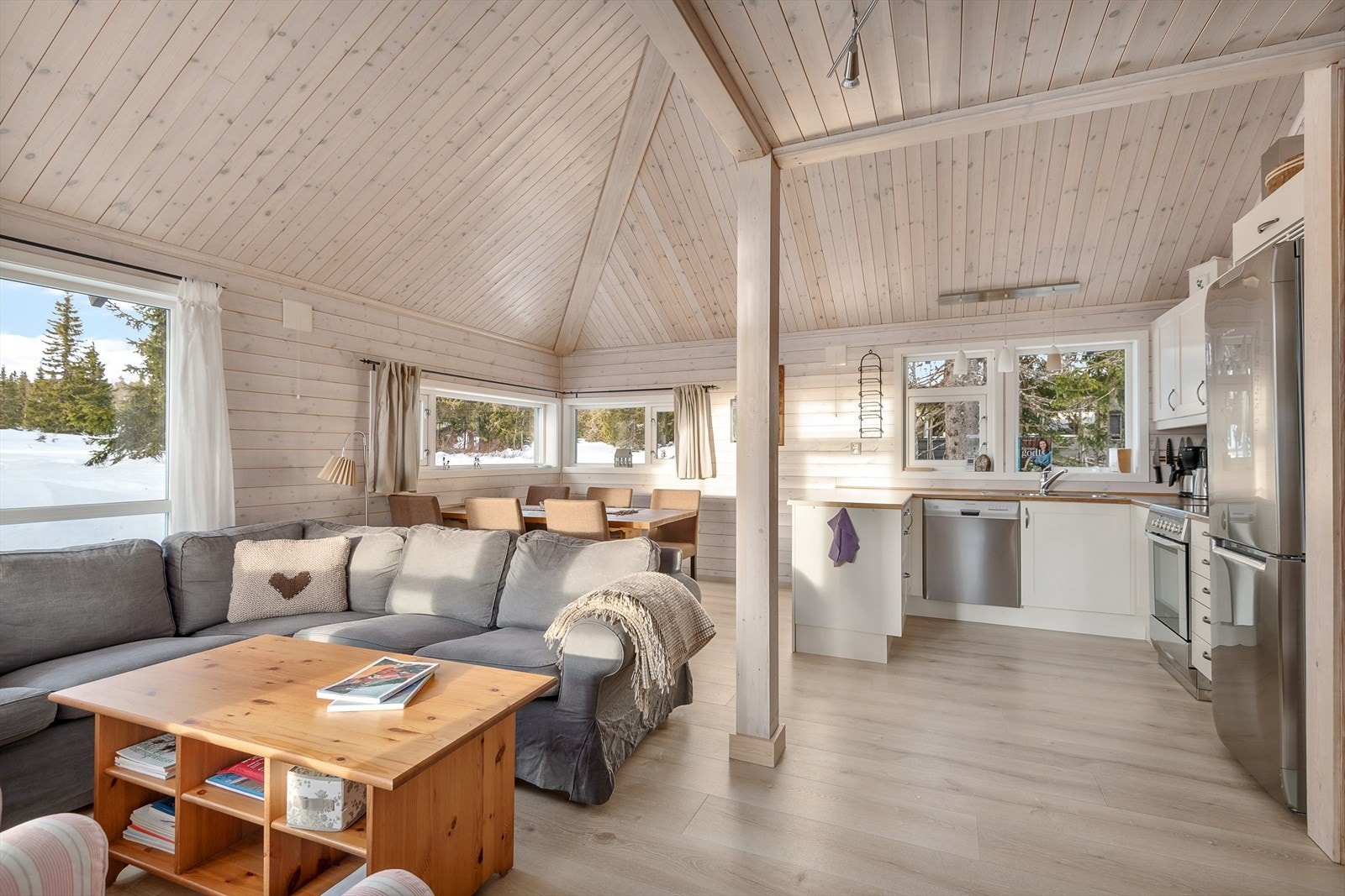 Det er en åpen løsning mellom stue og kjøkken i hytta. God takhøyde gir fin romfølelse. Galleribilde