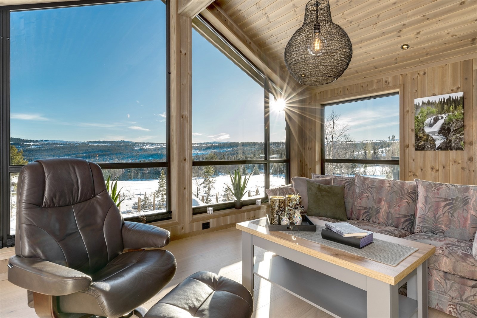 Stuen har raustet himling og store vinduer mot sør som gir en nydelig utsikt. Det er montert varmedempende vinduer mot sør. Galleribilde