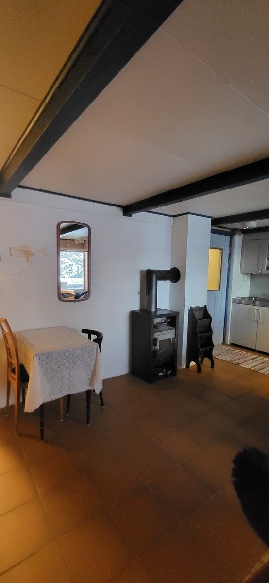 Spiseplass og peisovn, med kjøkkenet i bakgrunnen Galleribilde