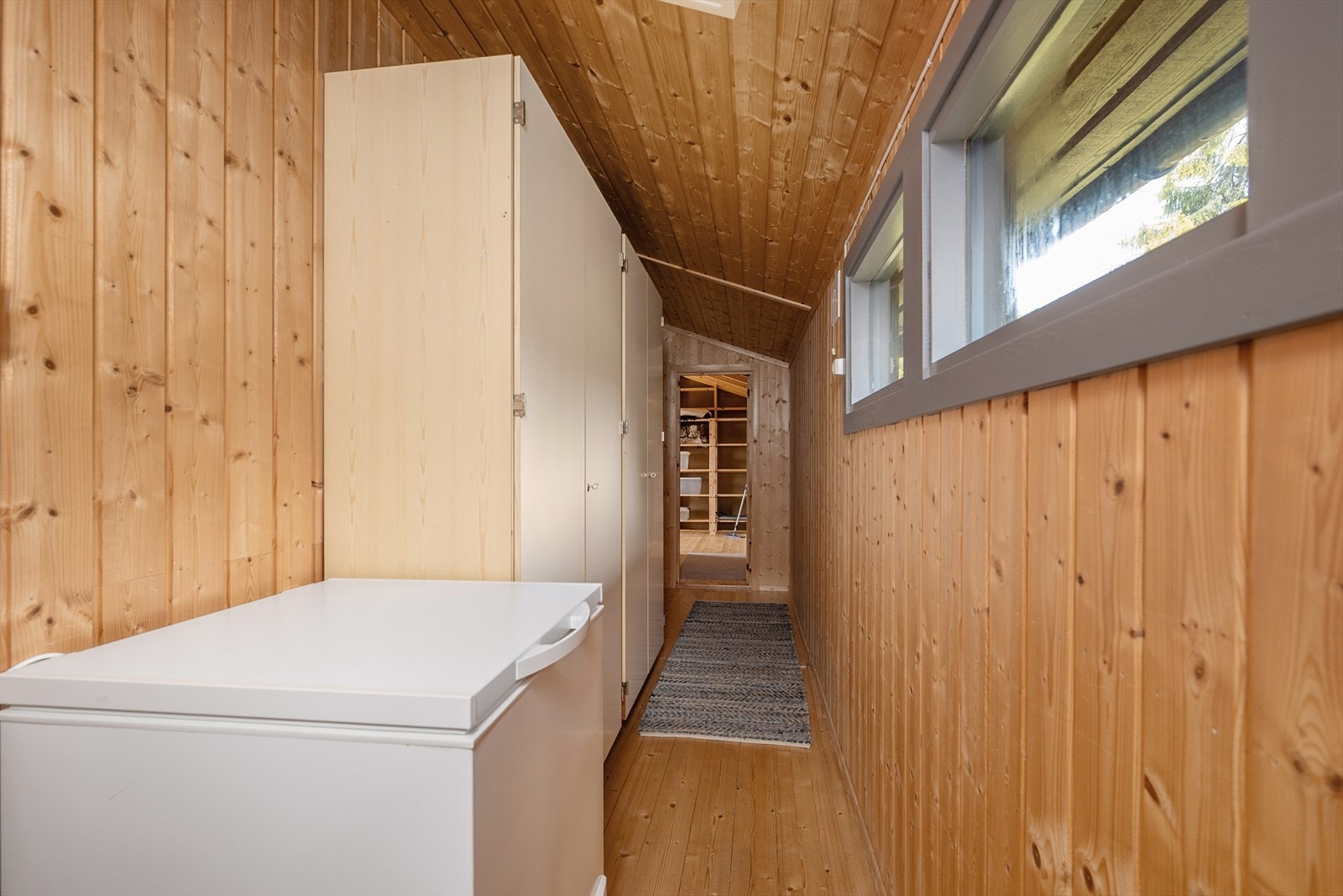 En romslig gang i den tilbygde delen gir adkomst til ett av soverommene og en stor bod. Her er det bl.a plassert garderobeskap. Galleribilde