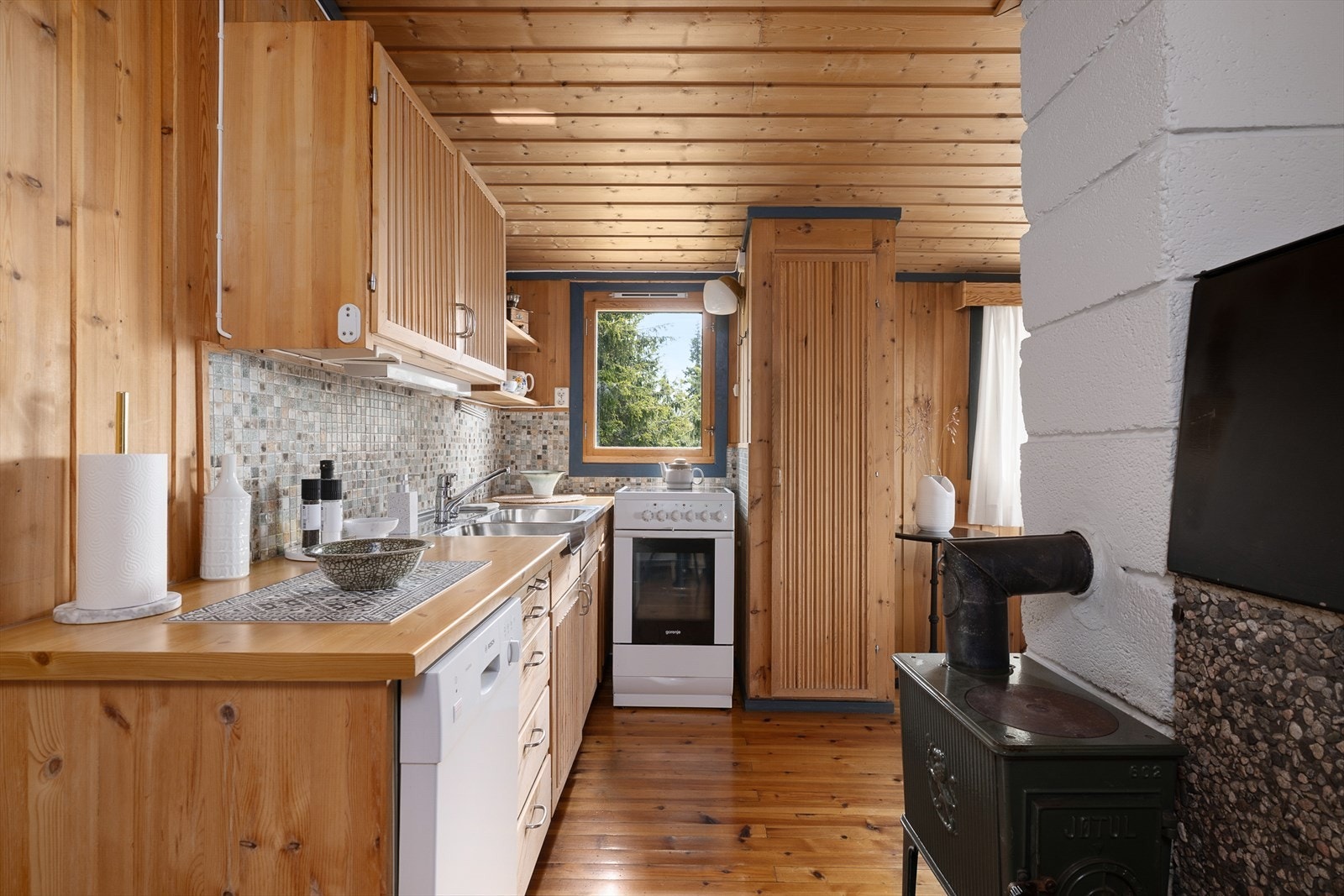 Et lite vindu over komfyren gir fint lys inn på kjøkkenet. Vedovnen sørger for god varme. Galleribilde