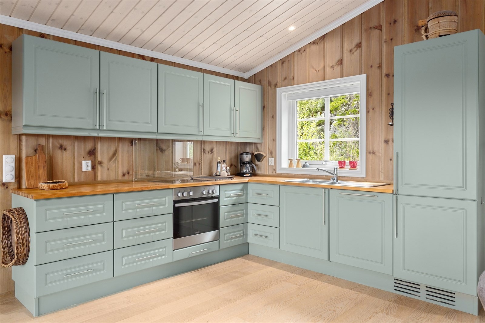 Kjøkkenet har en klassisk innredning med profilerte fronter i en fin grønntone og benkeplate i slitesterkt heltre. Galleribilde