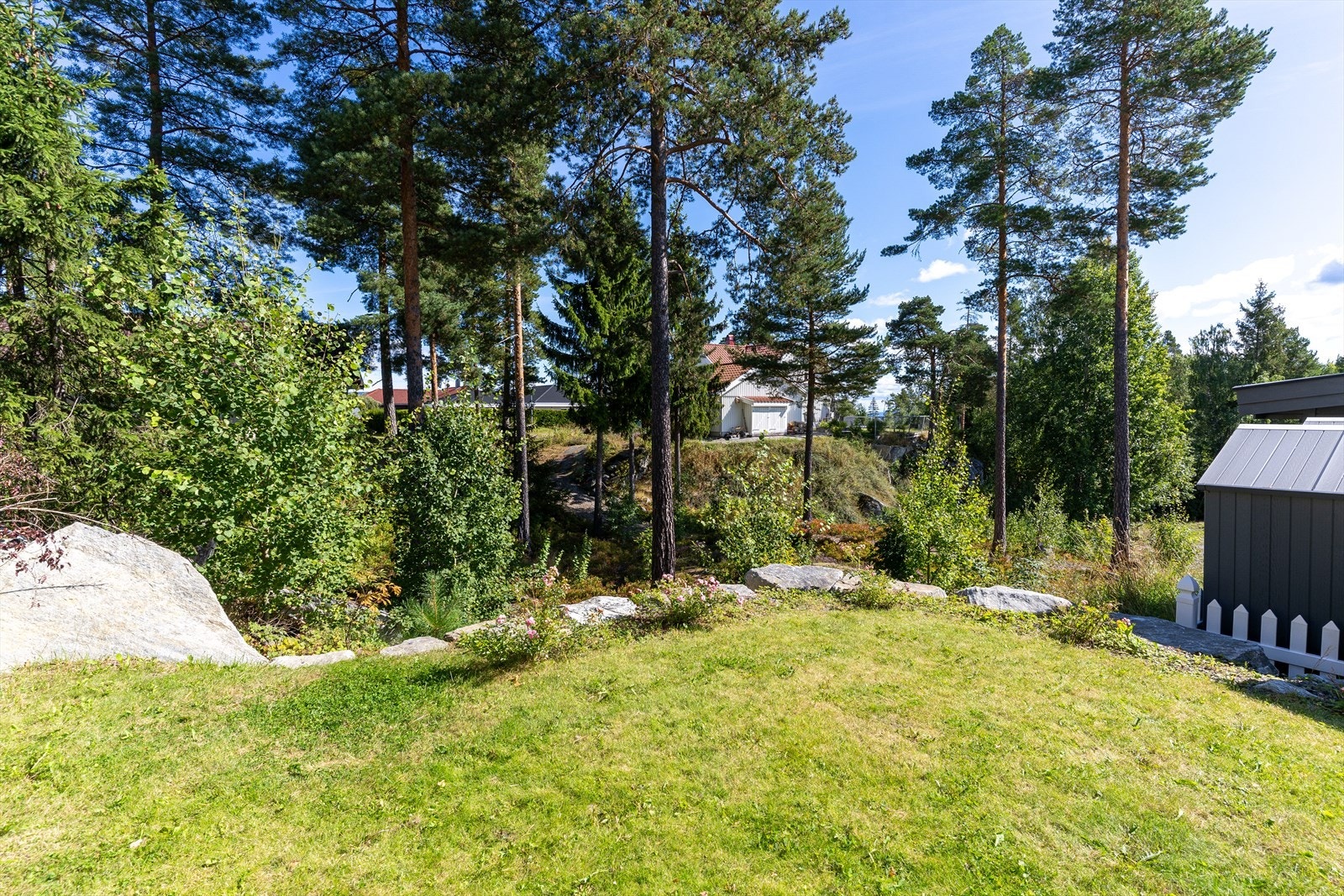 Skrånet terrengforhold. Belegningsstein i gårdsplass. Det er varmekabel under brostein i bakken opp til inngang. Det er nylig oppført gjerde mot nabo på nedsiden av boligen. Galleribilde