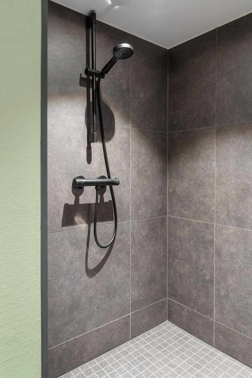 Badet har moderne innredning med klosett, benk med servant og speil med integrerte LED-lys Galleribilde