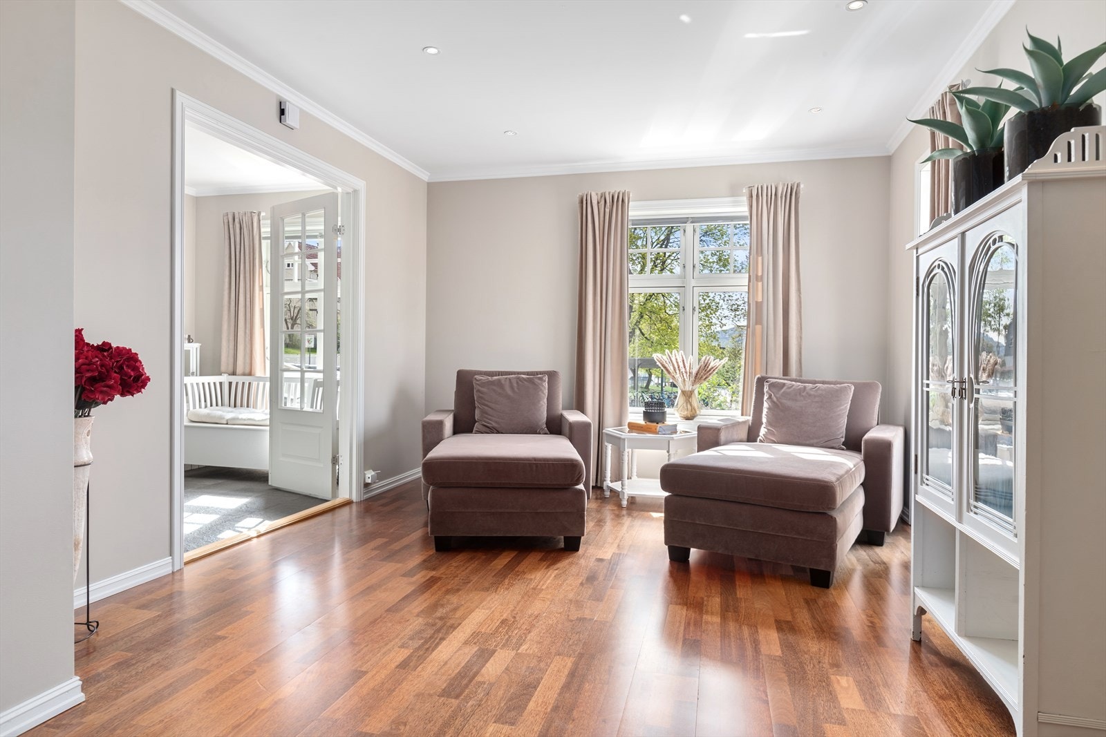 Romslig og innbydende stue inndelt i ulike soner med god plass til både sofagruppe og spisestue Galleribilde