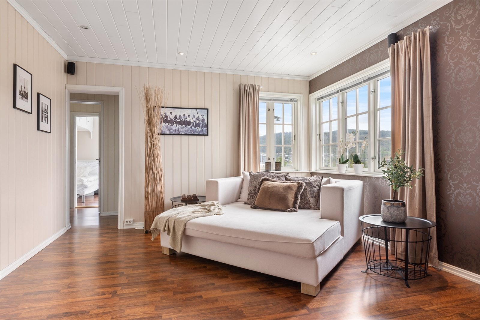 Romslig og innbydende stue innredet med stor sjeselong og god plass til øvrig møblement Galleribilde