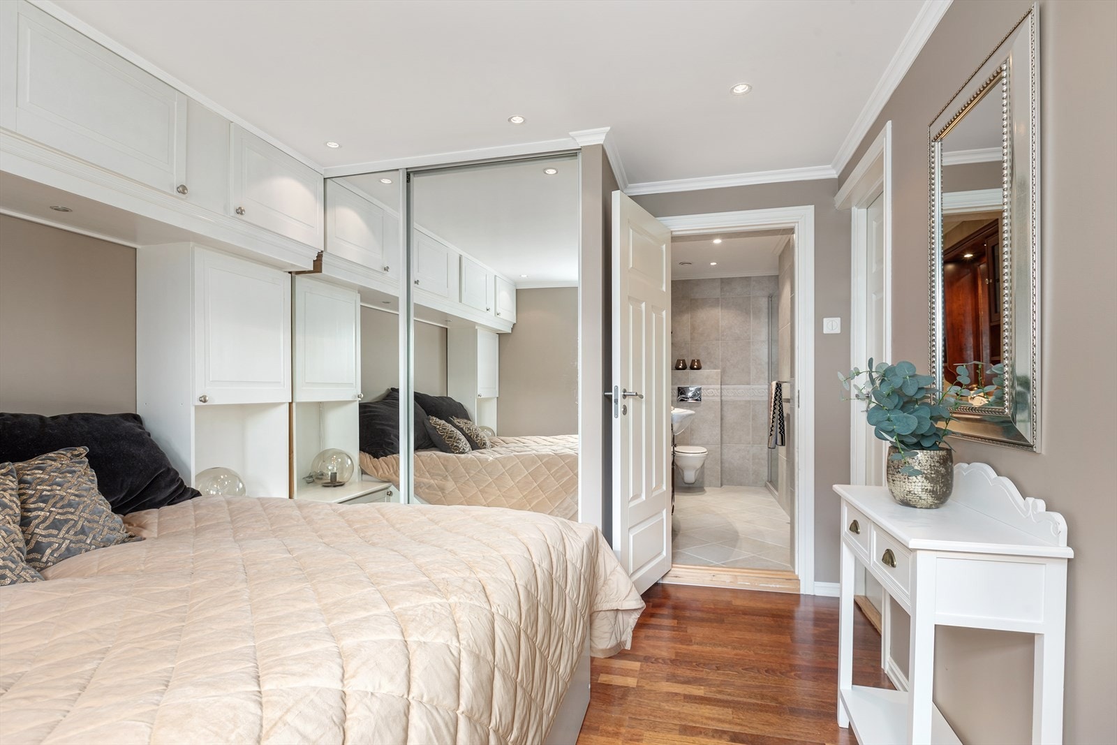 Romslig soverom med god oppbevaringsplass i form av både plassbygget skapinnredning og praktiske skyvedørsgarderober Galleribilde