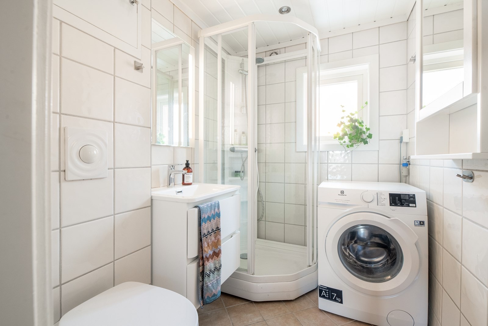 Lyst og moderne baderom totalrenovert av borettslaget i 2007. Badet har flislagt gulv med varmekabler, flislagte vegger og malt panel i himling. Rommet er innredet med servant, toalett, dusjkabinett og opplegg for vaskemaskin. Galleribilde