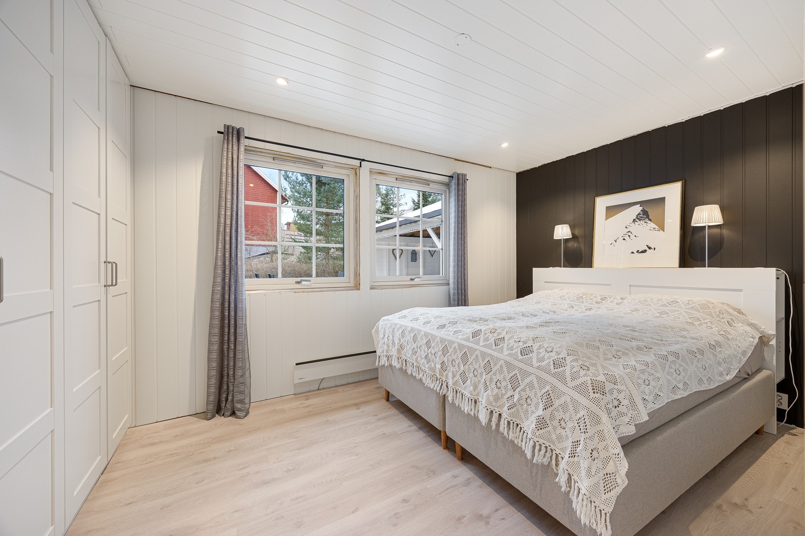 Boligen har tre gode soverom - hvorav hovedsoverommet ligger i første etasje. Her er det god plass til dobbeltseng og tilhørende nattbord - i tillegg sørger et stort, hvitt garderobeskap for praktisk oppbevaring. Galleribilde