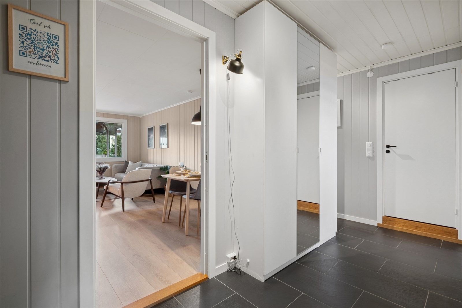 Entréen fremstår lys og innbydende med flislagt gulv og god plass til garderobe, skjenk og annet ønskelig møblement. Galleribilde