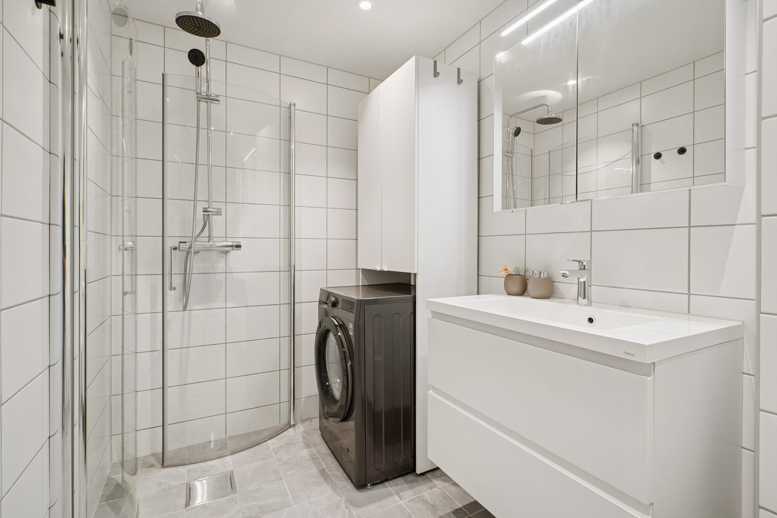 Dusjhjørne og opplegg for vaskemaskin gir praktiske løsninger for våtrommet. Galleribilde