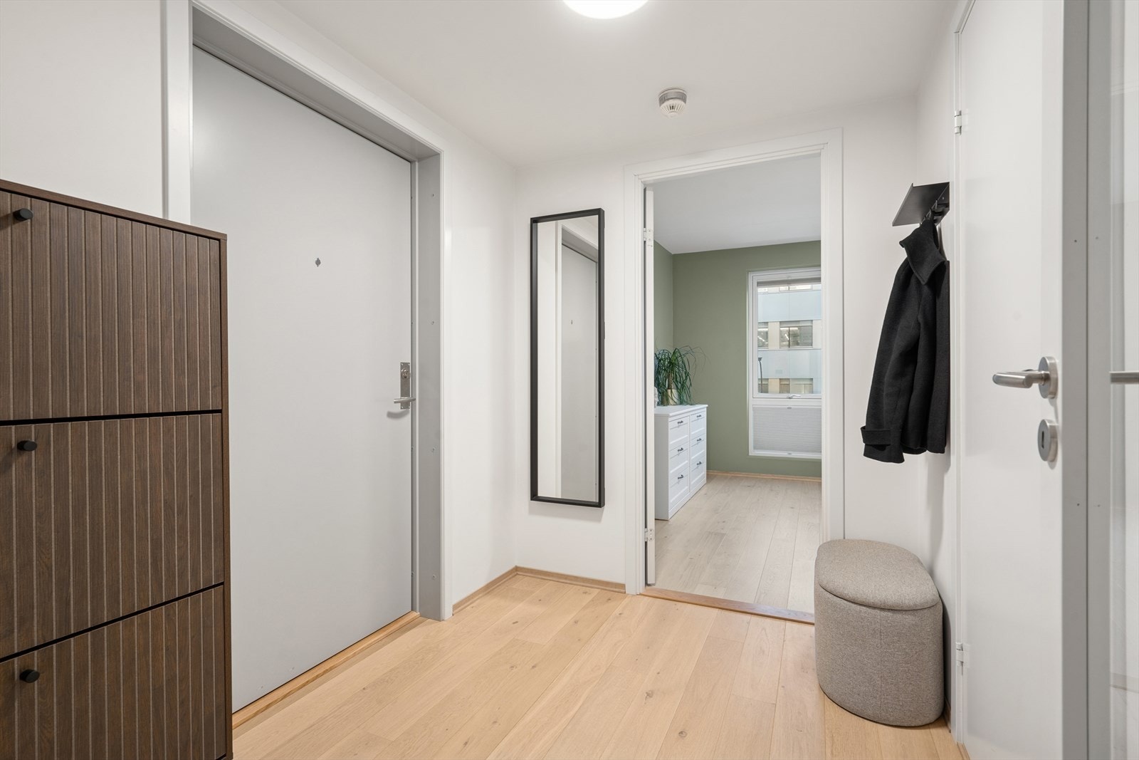 Entrèen gir et hyggelig førsteinntrykk, og er holdt i et nøytralt og tidsriktig fargevalg, noe som harmonerer med de øvrige rom i boligen Galleribilde