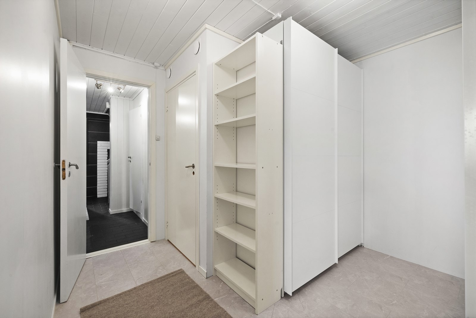 I underetasjen er det praktisk garderoberom med skyvedørsgarderobe og plass til skap og hyller Galleribilde