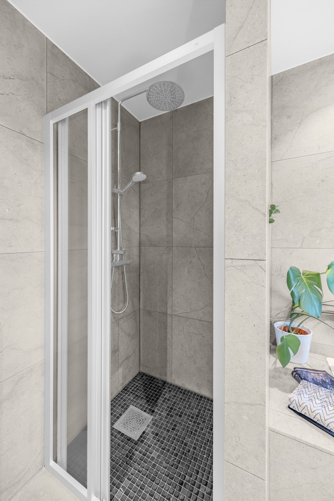 Dusjsonen har mosaikkfliser av typen Nero Marquina og natursteinsfliser på veggene. Galleribilde