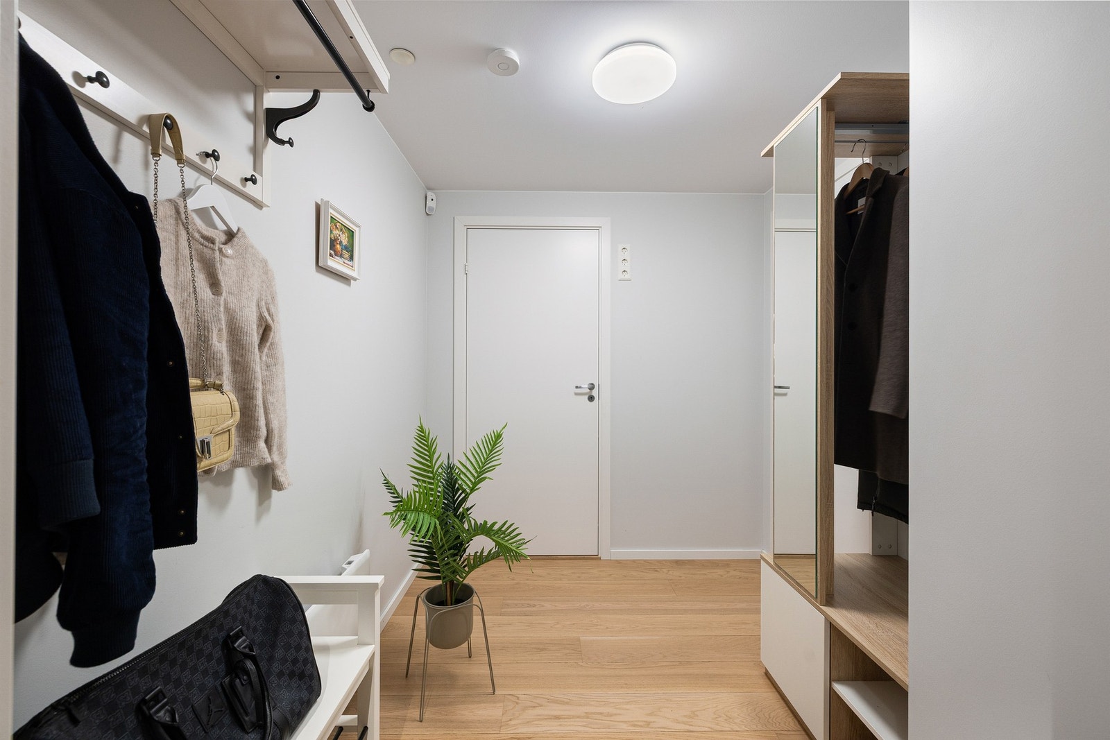 Rommet har praktiske garderobeløsninger med oppheng, hyller og knagger Galleribilde