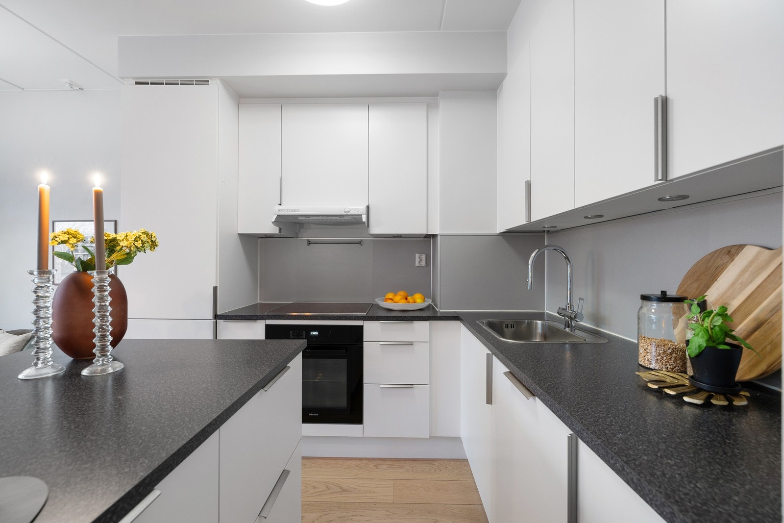 Kjøkkeninnredningen har integrerte hvitevarer som består av oppvaskmaskin, platetopp, komfyr, ventilator og kjøl/frys Galleribilde