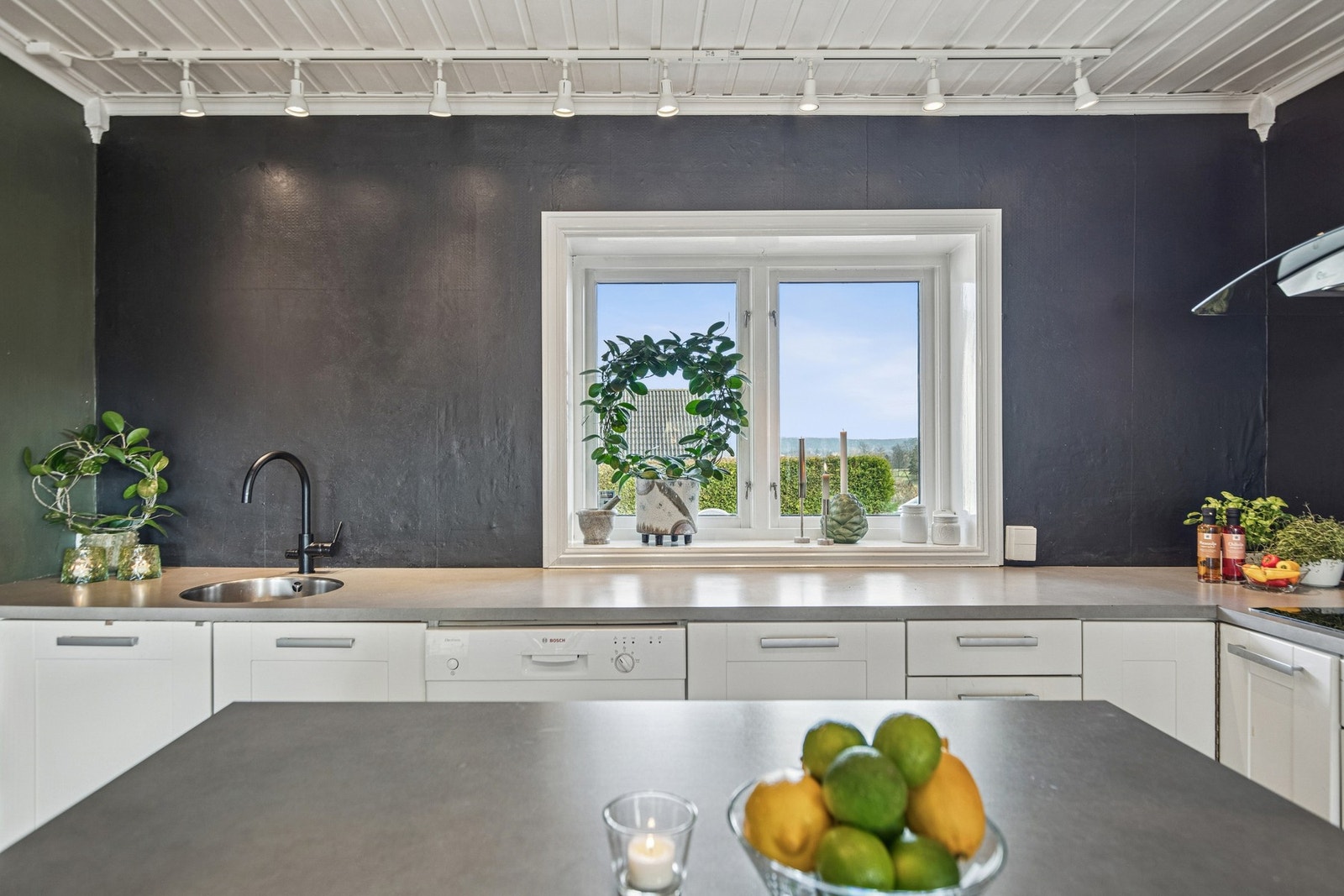 Innredningen er fra 2013, med hvite, profilerte fronter, nedfelt oppvaskkum og lysegrå benkeplate av laminat. Galleribilde