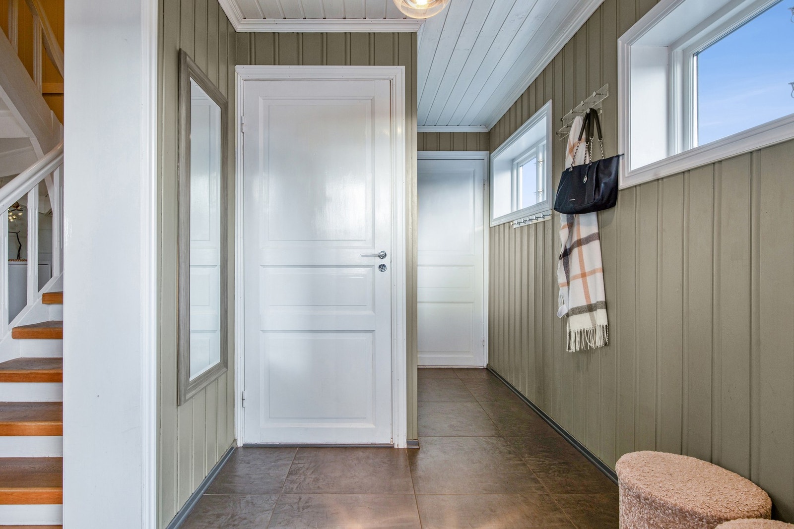 Vel inne gir entréen et godt førsteinntrykk, med varmekabler, store, mørke gulvfliser og panelvegger. Galleribilde