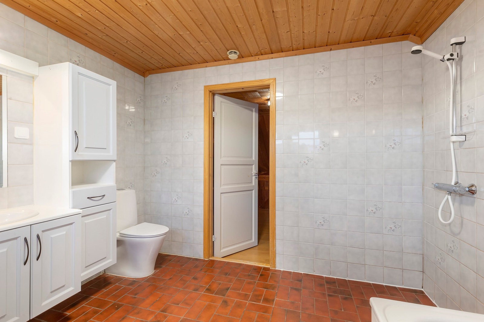 Badet er utstyrt med badekar, åpen dusj, wc, baderomsinnreding, servant og servantskap. Galleribilde