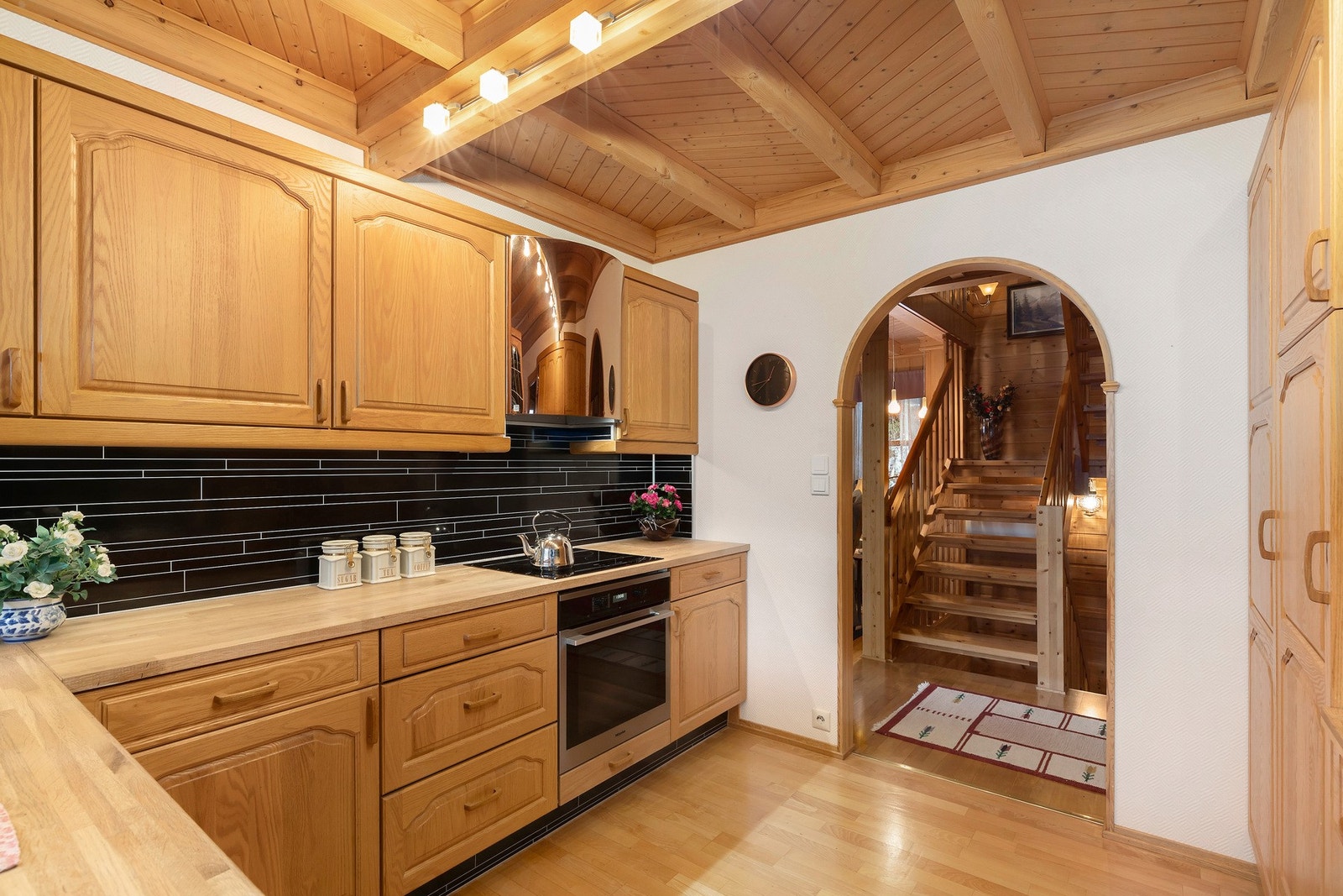 Kjøkkeninnredning med benkeplate i heltre - Utstyrt med integrert komfyr, platetopp i benk, oppvaskmaskin og kjøleskap. Galleribilde