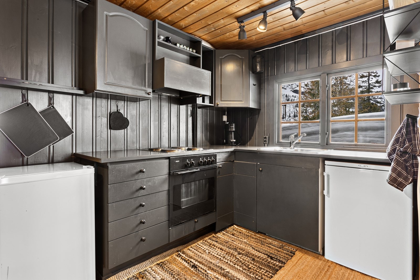 Enkelt og klassisk hyttekjøkken, malt i en tidsriktig gråfarge. Galleribilde