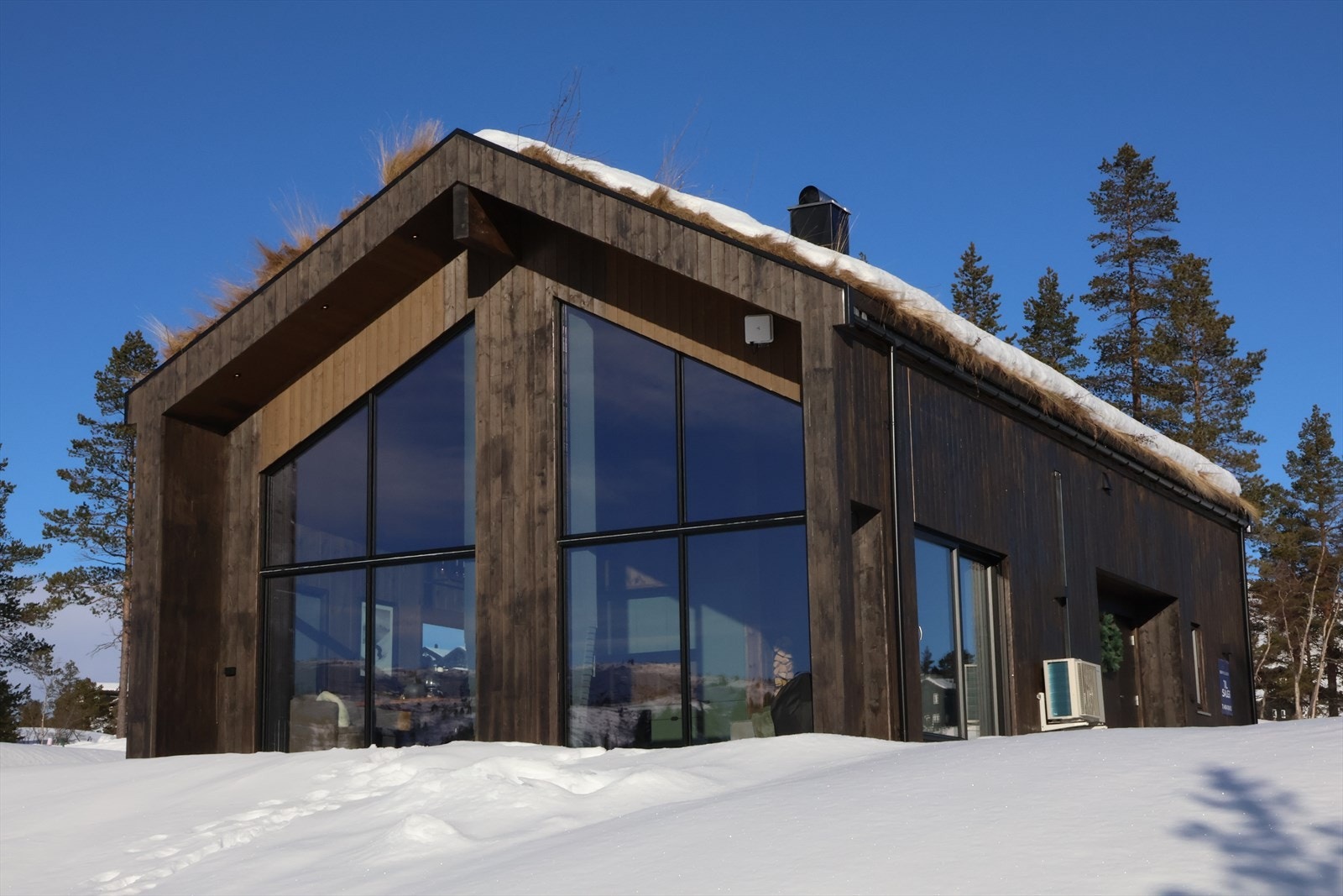 Denne flotte hytta har vinduer fra tak til gulv i stuen i 1. etasjen. Galleribilde