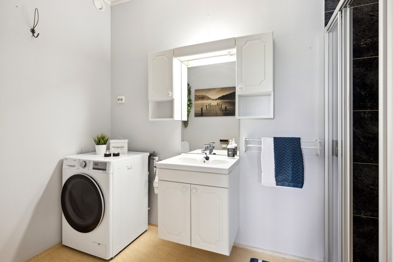 utstyrt med servant med profilerte fronter og ettgreps blandebatteri, speil og lys. Videre finnes en dusjnisje med dusjdør Galleribilde