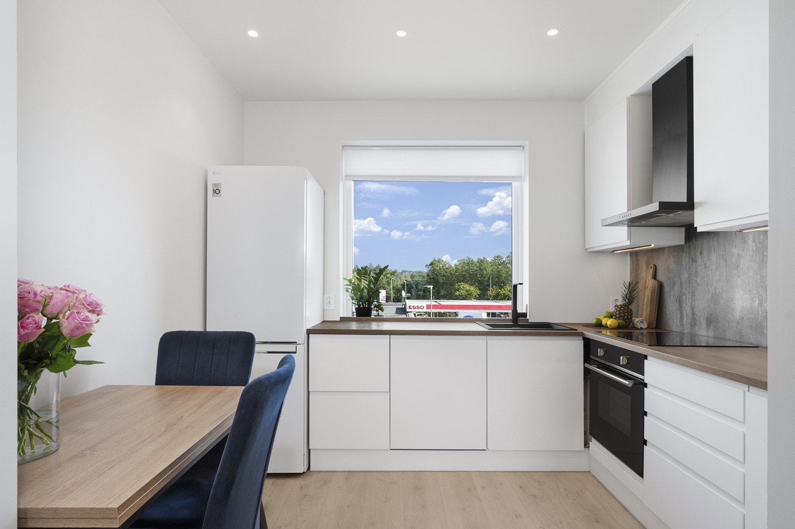 Kjøkkenet har innredning med hvite, slette fronter som gir et tidløst uttrykk, kombinert med en mørk laminat benkeplate og servantkum i kompositt. Galleribilde