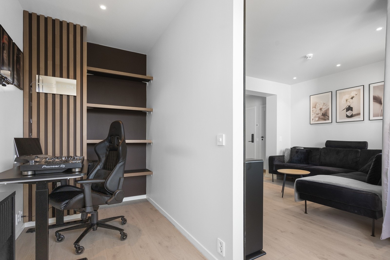 I stuen er det satt opp en lettvegg som deler rommet inn i flere funksjonelle soner. Dagens innredning består av en hyggelig sofakrok og en praktisk hjemmekontorplass med skrivepult på andre siden. Galleribilde