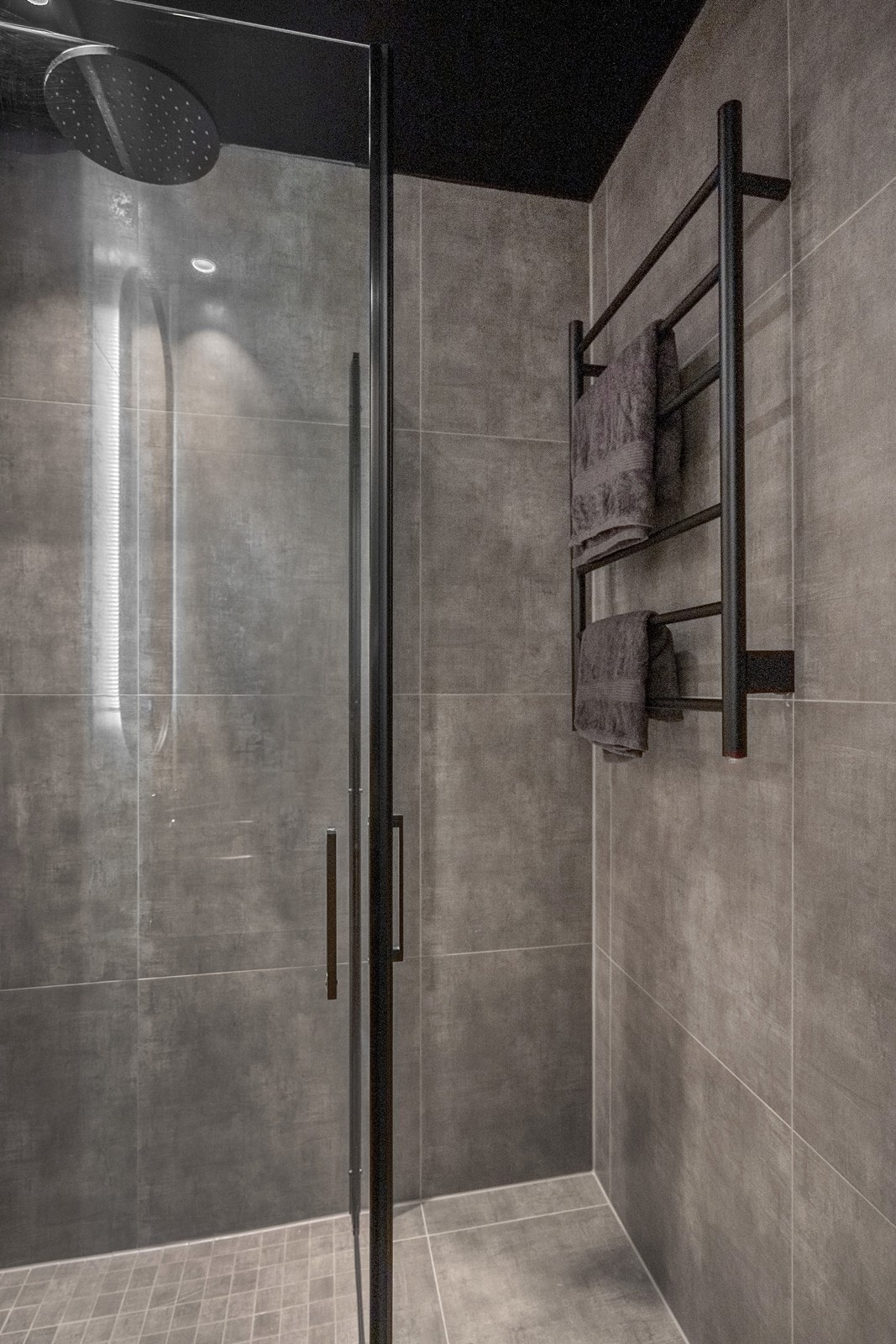 Badet fra 2025 er gjennomført med flislagte overflater, sorte detaljer og slettmalt tak med downlights. Galleribilde